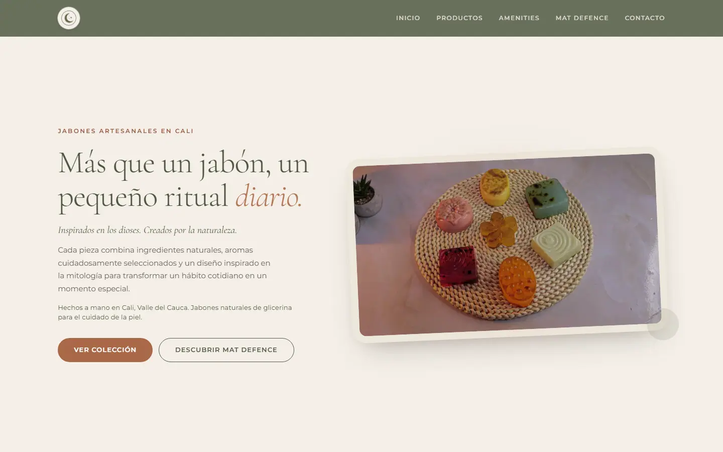 Página de inicio de MEI: titular «Más que un jabón, un pequeño ritual diario» junto a una foto de jabones artesanales de colores sobre un individual tejido.